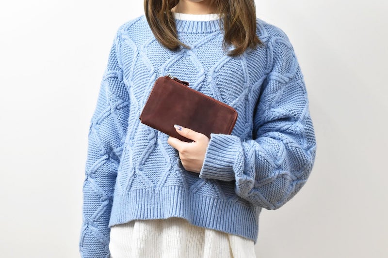 ハレルヤの小さい長財布『TIDY2』を女性が持っている様子